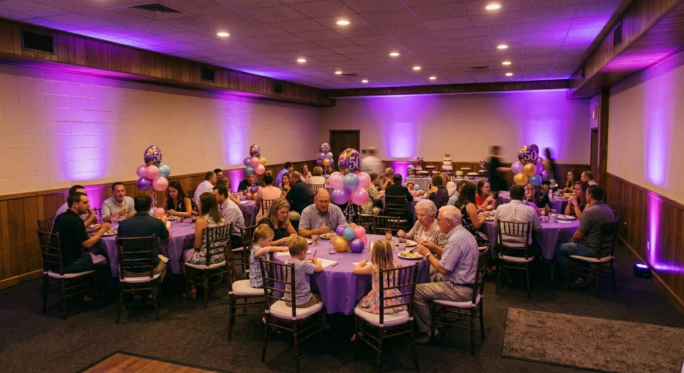 Purple uplighting rental illuminating the block walls of a small banquet hall during a 50th birthday party with mixed-age family guests